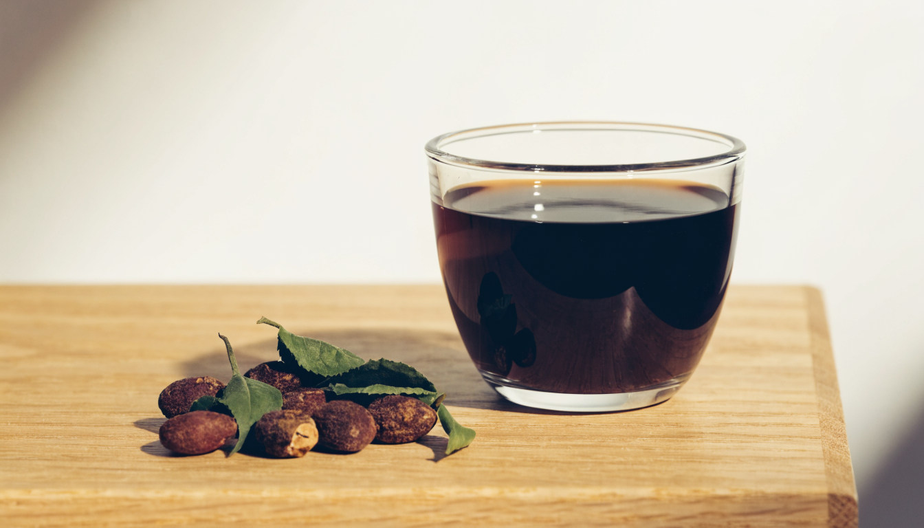 Tasse de cafe noir a cote de graines de guarana et de feuilles de the vert